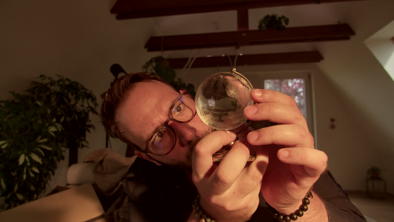 Man Examining a Small Globe