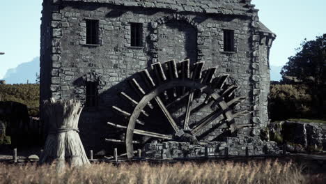 a stone watermill with a large wooden wheel