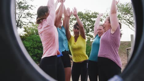 Female-friends-enjoying-exercising-at-boot-camp-together