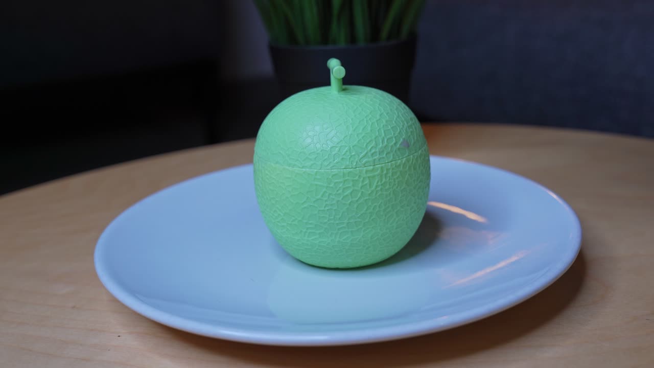 Close-up of hand twisting open a melon-shaped dessert container. Great for food reveal videos, product showcases, ASMR, and visually satisfying transitions.