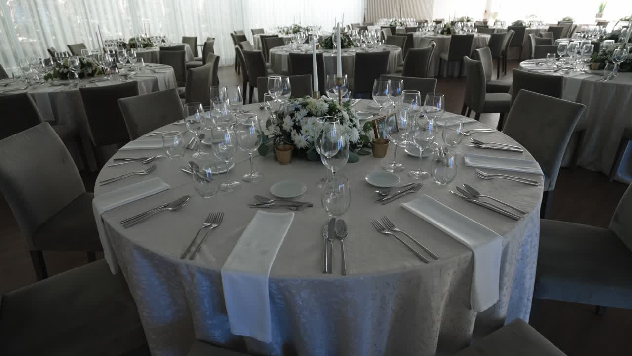Beautifully arranged wedding reception tables with floral centerpieces and glassware