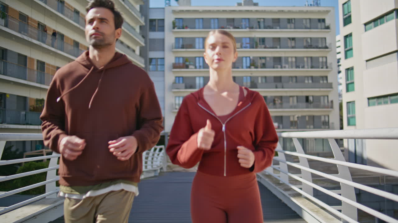 Urban couple running morning together. Fit people do cardio endurance training