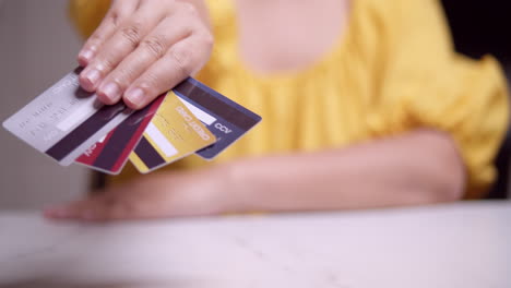 Mujer-Vestida-De-Amarillo-Presentando-Sus-Diversas-Tarjetas-De-Crédito-A-La-Cámara.