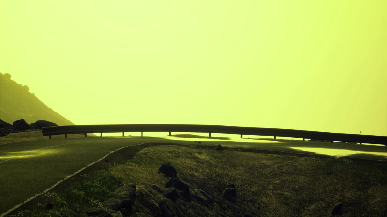 Mysterious road winding through foggy landscape under bright yellow sky