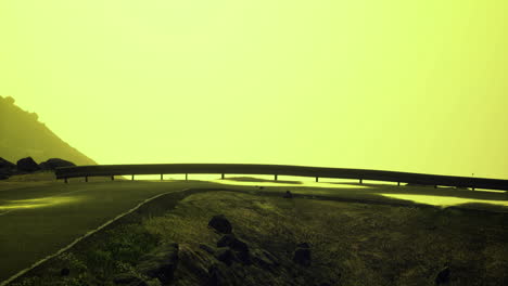 mysterious road winding through foggy landscape under bright yellow sky