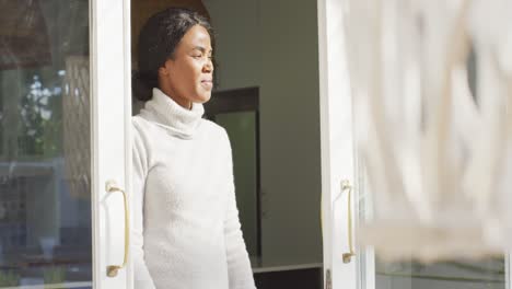 video of happy and relaxed african american woman looking outside window