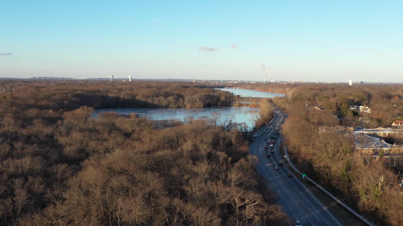 una vista aérea de un barrio suburbano en long island justo antes del atardecer, lo suficientemente alto como para ver el horizonte, las carreteras locales y los lagos congelados
