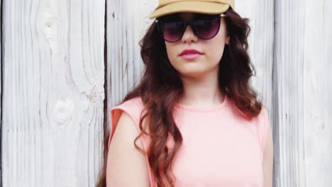 fashionable woman standing against wooden background