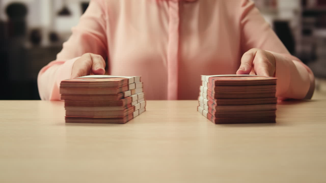 Woman holding a stack of money on a table