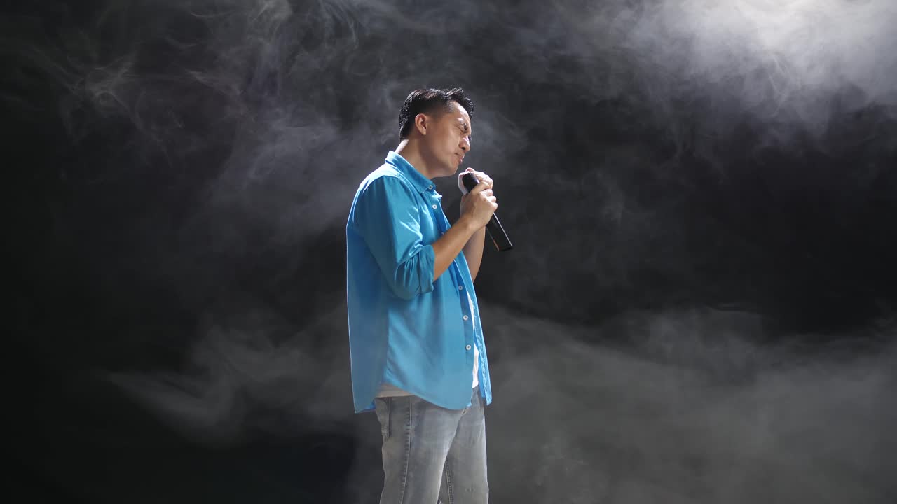 연기가 있는 무대에서 노래하는 남자