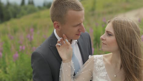 a bride and groom kiss and smile in a field of flowers