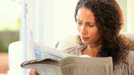 una mujer joven leyendo un periódico