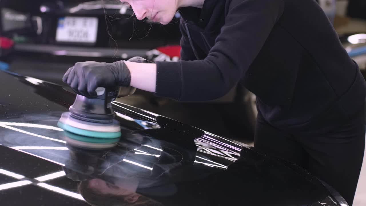 페인트 복원을 위해 기계와 폴리셔를 사용하는 전문 자동차 디테일링.