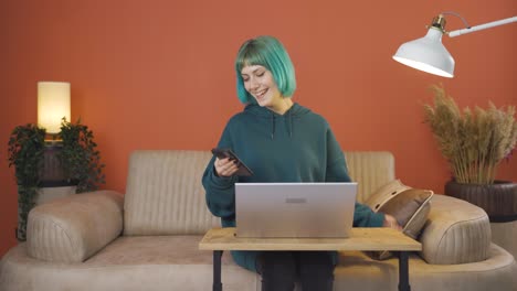 Young-woman-laughing-at-phone-message.