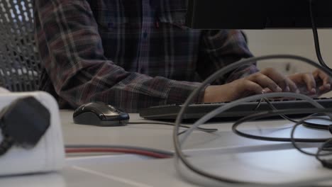hombre adulto casual inteligente escribiendo en el teclado en el escritorio en la oficina