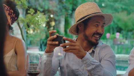 cool-asian-man-taking-photo-with-friend-using-smartphone-best-friends-at-dinner-party-enjoying-summer-celebration-sharing-vacation-memories-on-social-media-4k