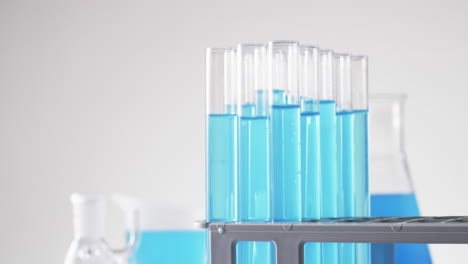 Video-of-glass-laboratory-test-tubes-with-blue-liquid-with-copy-space-on-white-background