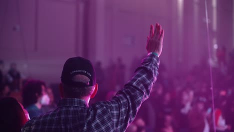 man raising their hands in a concert