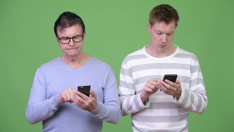 senior handsome man and young handsome man using phone together