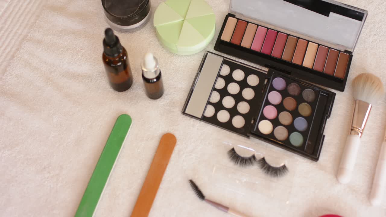 When camera is panning right, makeup palette and brushes are being revealed to showcase flat lay
