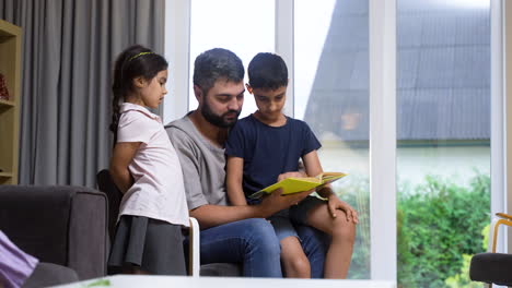 father, son and daughter in the living room.