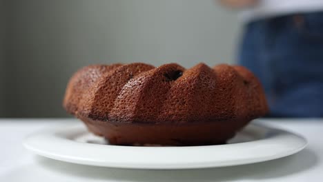 woman dusting a bundt cake with powdered sugar