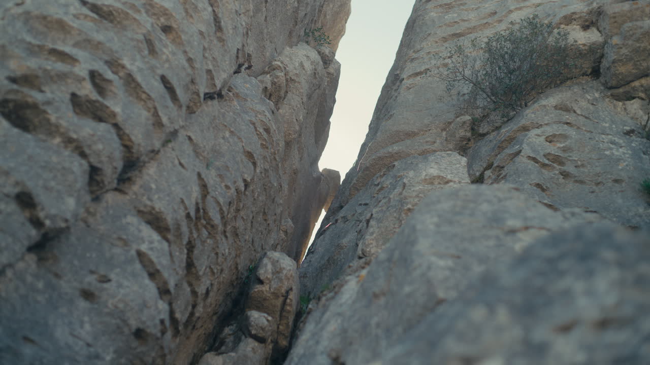 Smal klippepassage med lys mellem kalkstensvægge i El Torcal de Antequera, Spanien, der fremhæver karstformationer, erosionsmønstre og dramatiske naturlige teksturer.