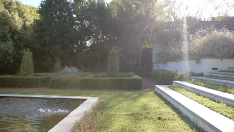 sunlight streaming over modern garden with neatly trimmed hedges and steps, copy space