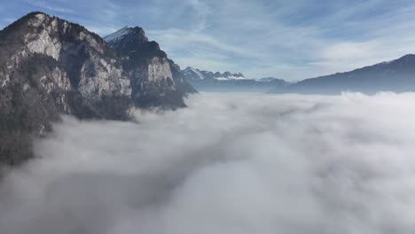 majestic cliffs amidst walensee fog, switzerland aerial above clouds