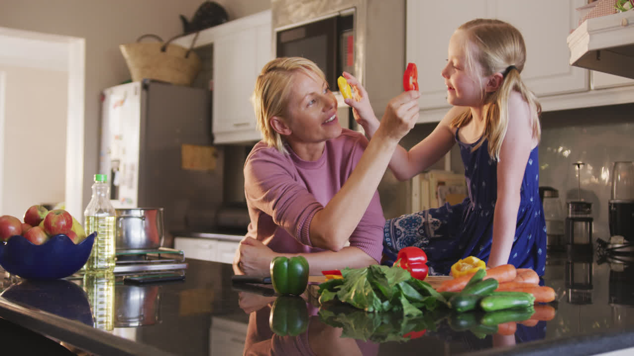 боковой вид белой женщины, готовящей с дочерью дома
