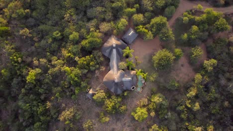 vista aérea de arriba hacia abajo de hermosas cabañas construidas en medio de una densa vegetación en sudáfrica