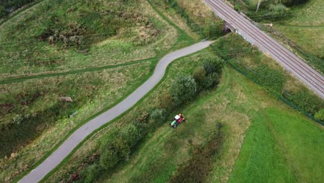 tractor in field driving along track, aerial shot distant view