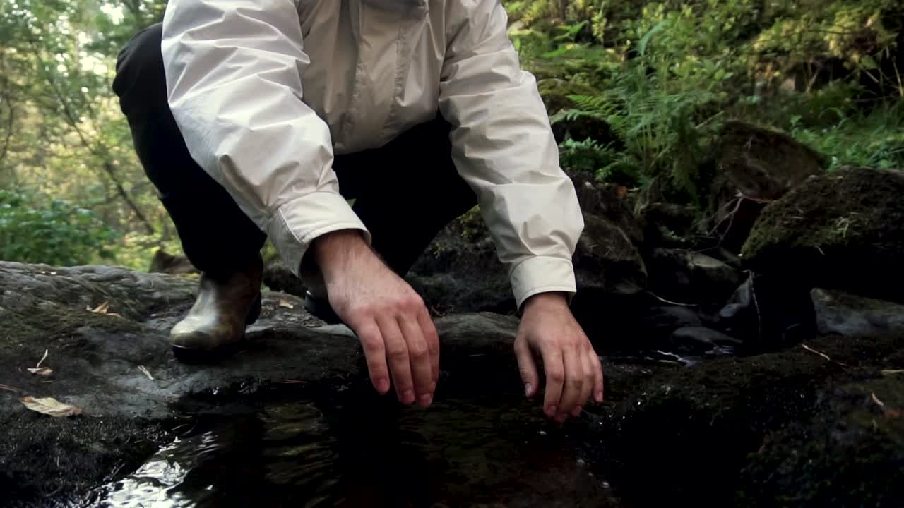 숲 속 의 작은 하천 을 조사 하는 사람
