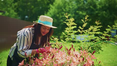 woman in straw hat tending to vibrant flowers in a lush garden during sunny day