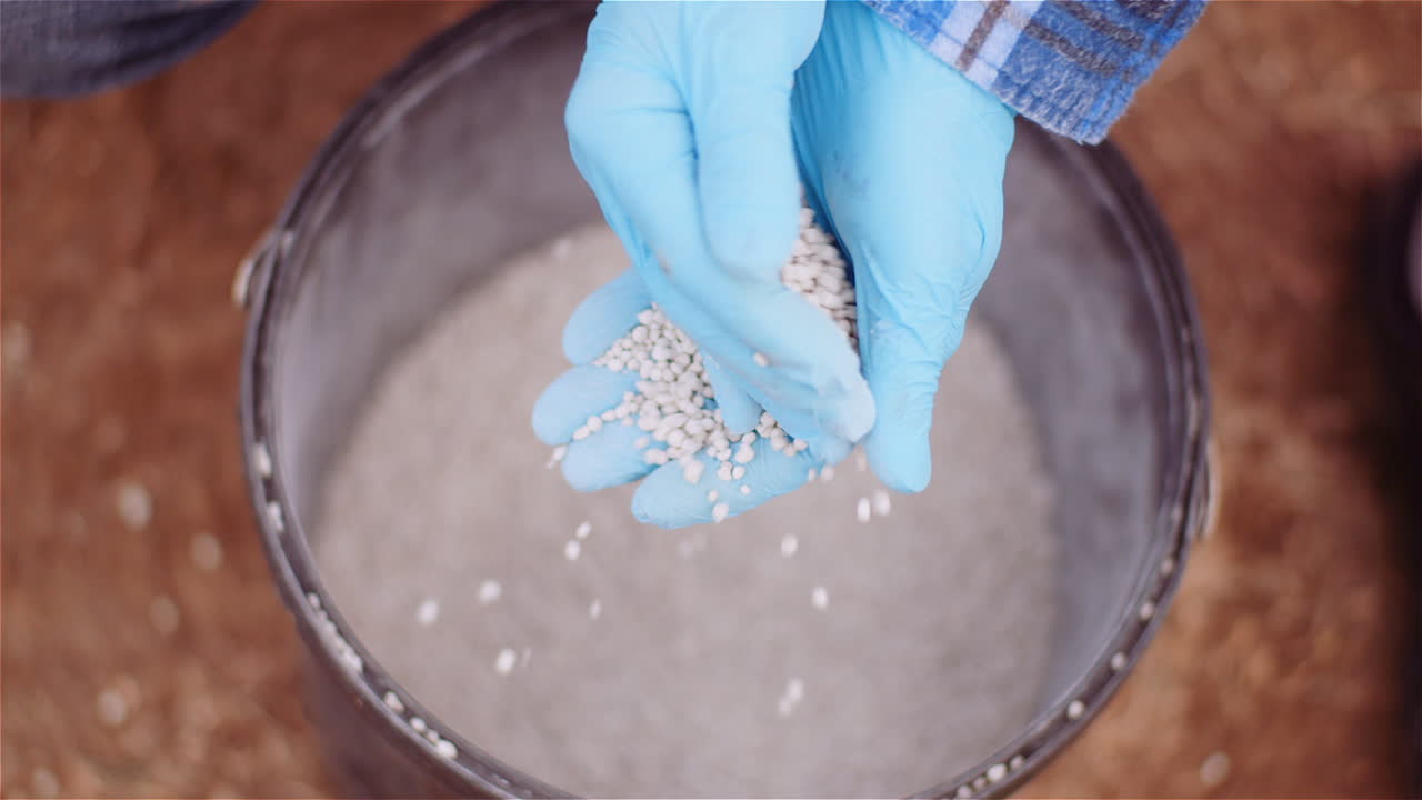 농업 분야에 비료를 주기 전에 손에 제초제 비료를 검사하는 농부 5