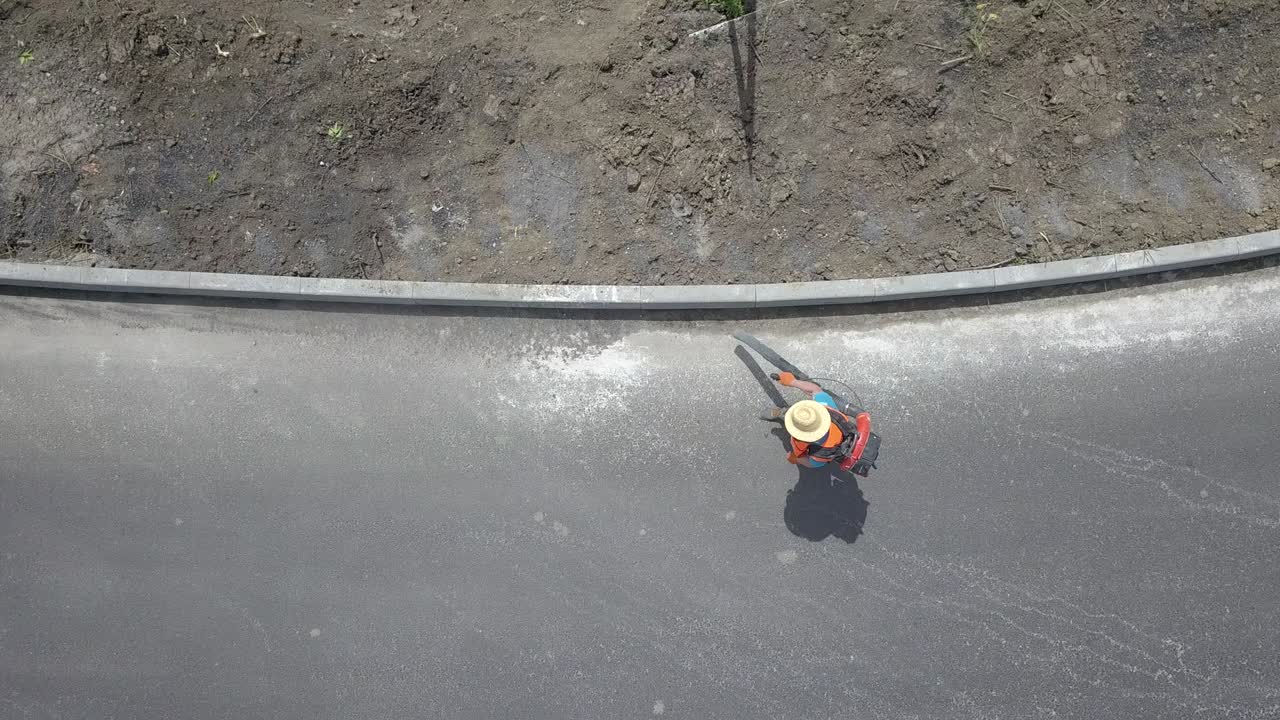 Worker, cleaning the streets with a breeze of air. Preparation for asphalting.