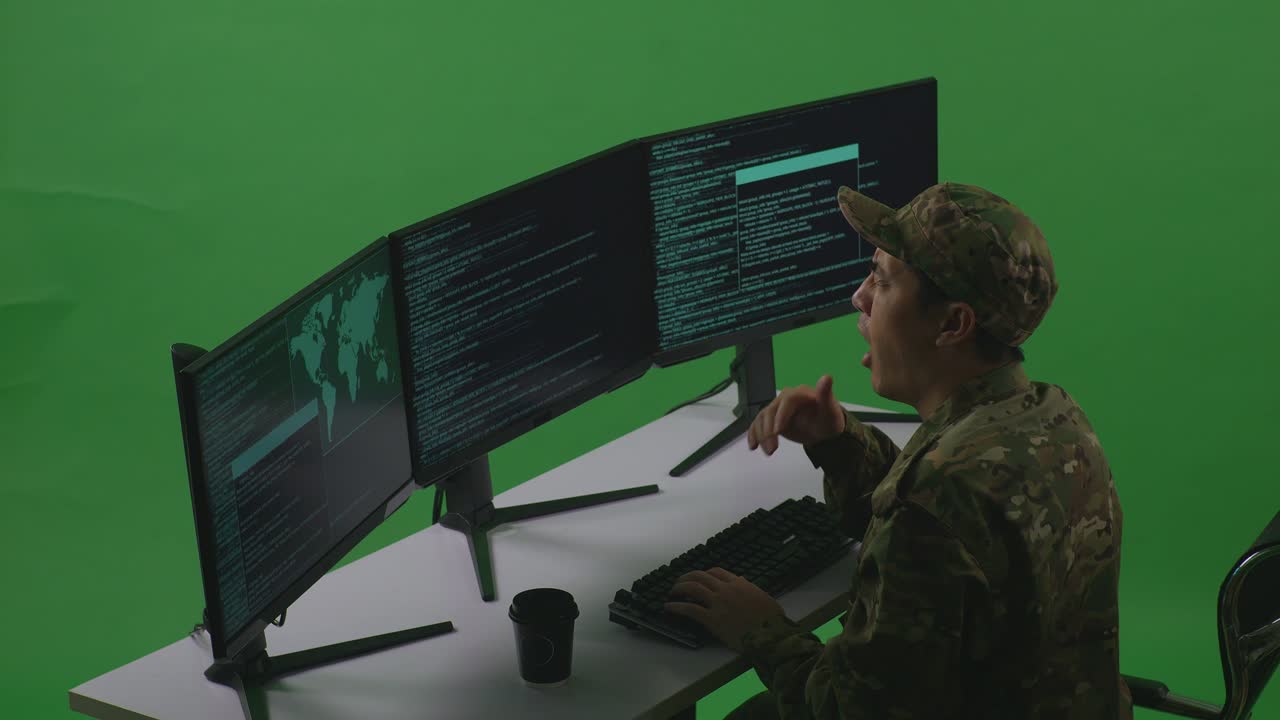 Side View Of Tired Asian Man Soldier Developer Yawning Before Sleeping While Write Code With Multiple Computer Screens In Green Screen Studio