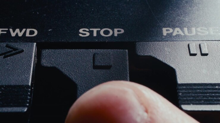 Extreme Close Up of Finger Pressing Stop Button on Retro Audio Deck
