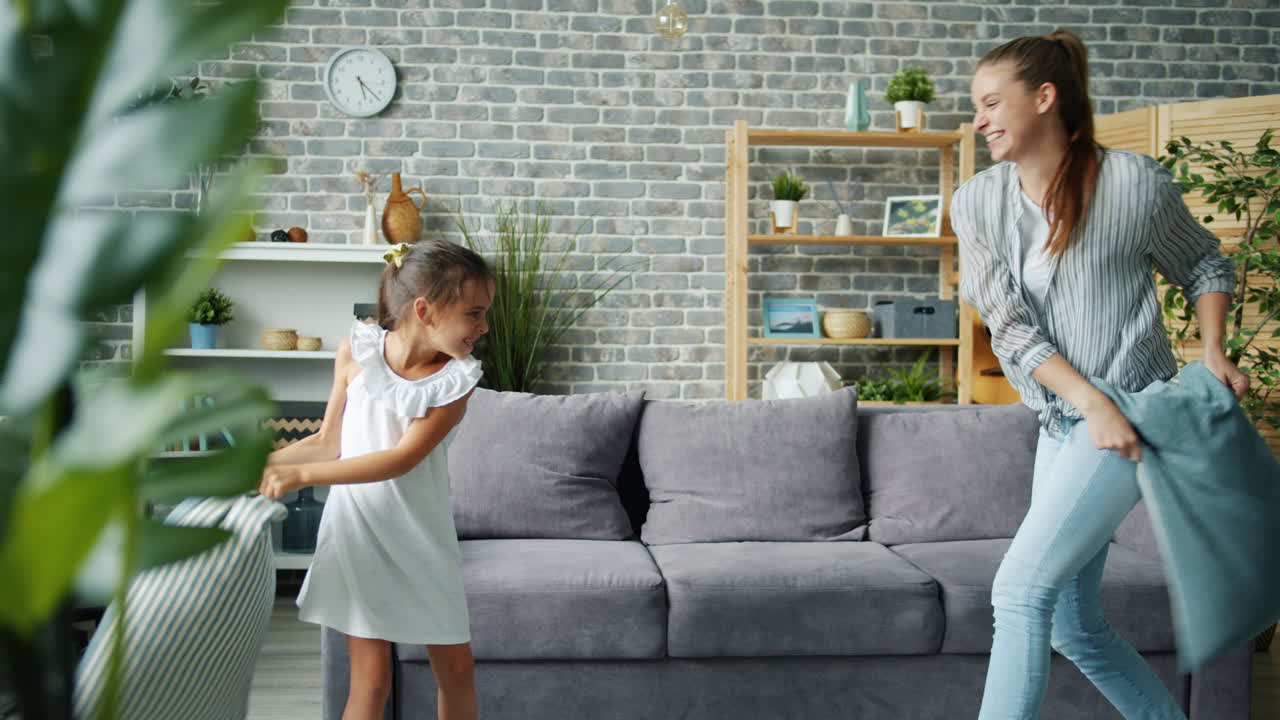Sisters Having a Pillow Fight at Home