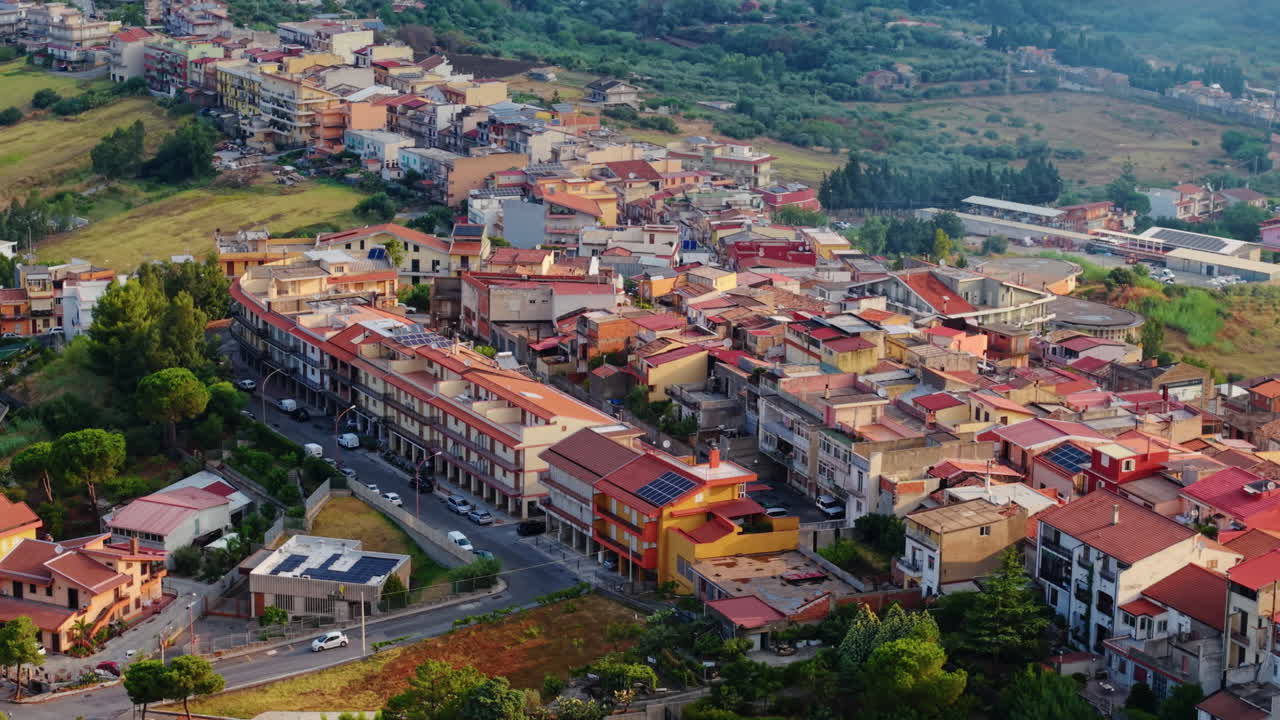 Villaggio siciliano in Italia, vista drone di tetti rossi, edifici residenziali, strade locali e paesaggio circostante