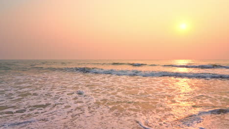 small ocean sea waves on a sandy beach during sunset