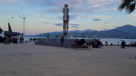 tourists and locals have fun after sunset near ali and nino statue in batumi georgia