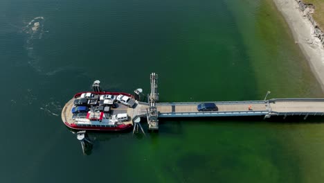 aerial view of the final car driving onto the herron island private ferry