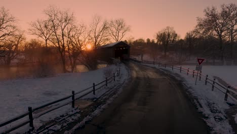 un buggy amish tirado por caballos entra en el puente cubierto de hunsecker's mill al atardecer lancaster, pennsylvania