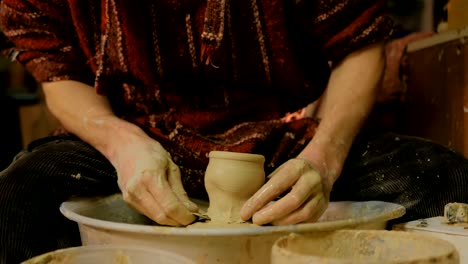 professional male potter working in workshop, studio