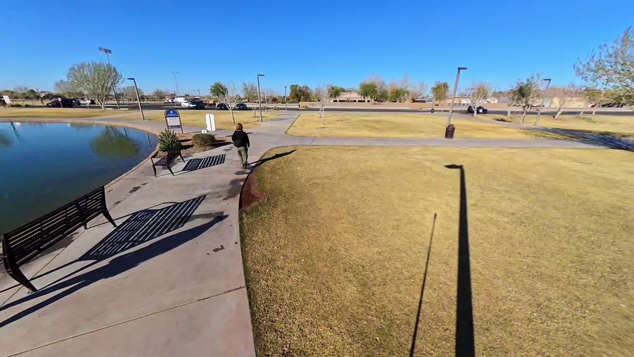Static Red haired male walking by a lake in Mansel Crater Park in Queen Creek Arizona.