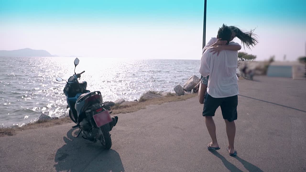 검은색과  ⁇ 색 드레싱을 입은 남자가 여자를 들어 올리고 키스합니다.