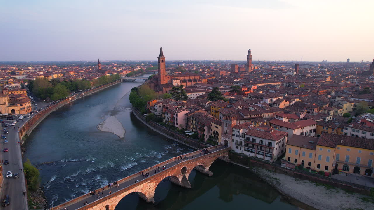Traffic around Verona most famous bridge at sunset. Aerial dolly out