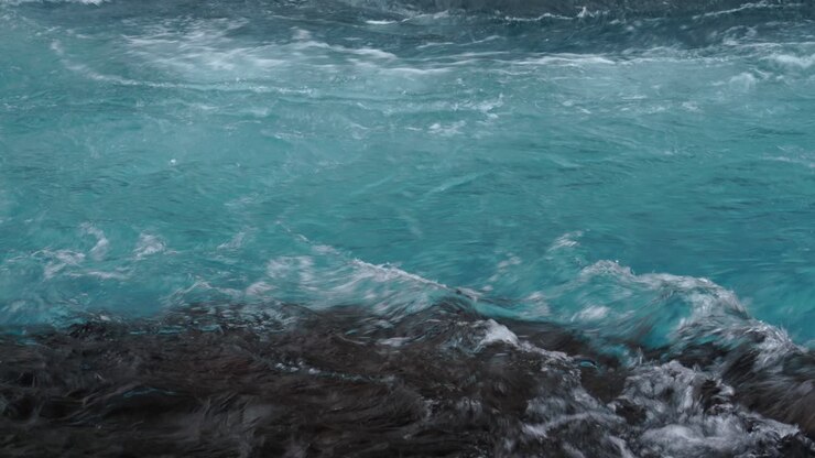 Potente acqua blu e cristallina di un fiume che scorre tra le rive dell'Islanda durante il giorno - primo piano panoramico