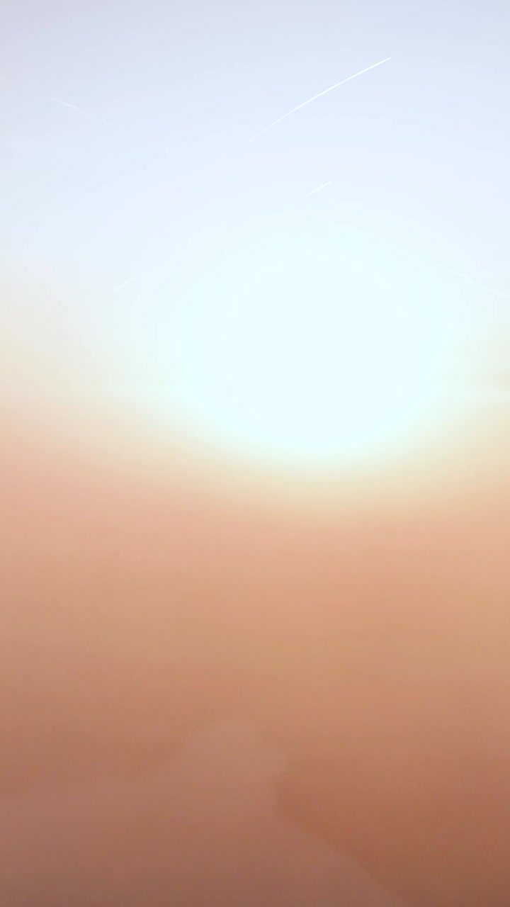 Golden Haze Over a Subtle Horizon with Distant Contrails